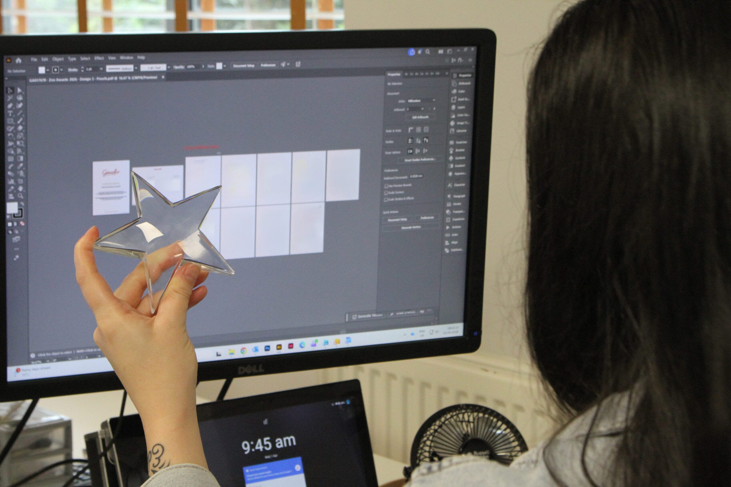 a trophy designer looks at proofs and holds a crystal star trophy